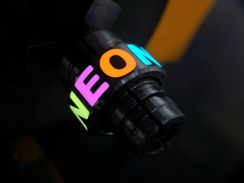 Ring mit Inschrift "NEON" leuchtend auf Halterung